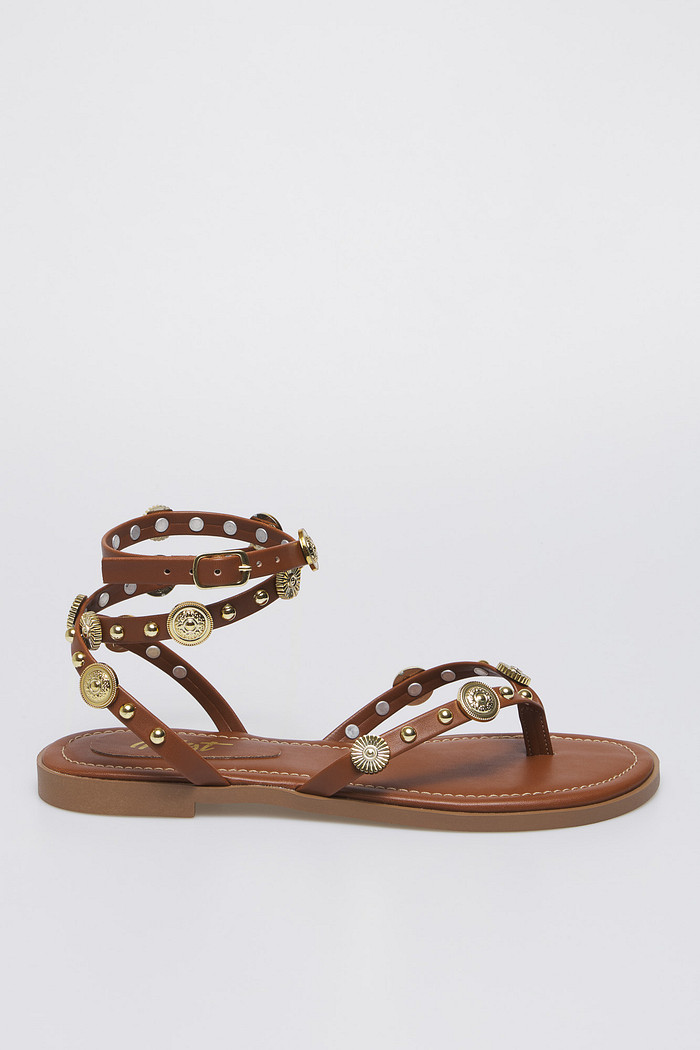 Sandália Luna Camel, uma sandália gladiadora com apliques dourados.
