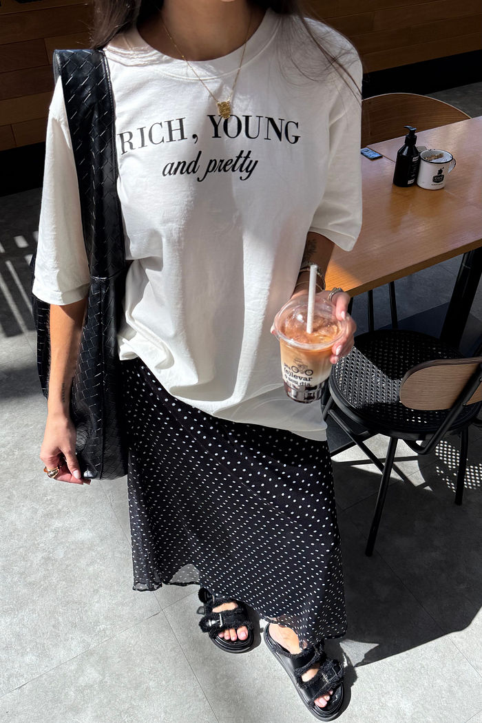 Saia midi de tule com estampa poá, leve e fluida, com forro embutido e cós elástico confortável.