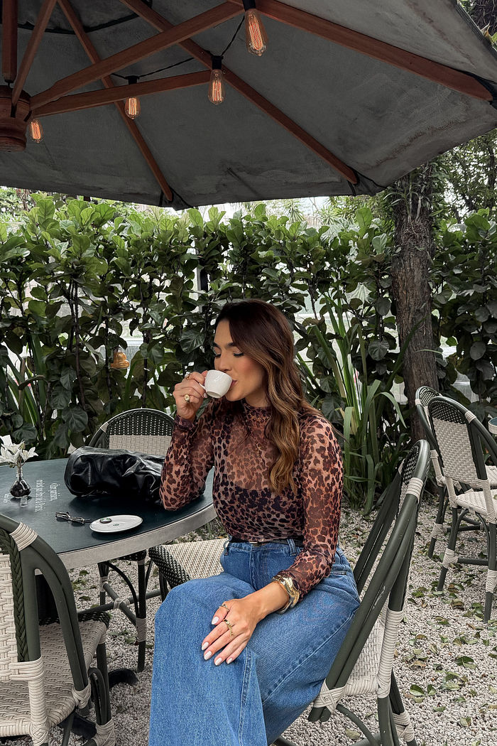 Blusa de tule com estampa animal print, manga longa, ajustada ao corpo e com leve transparência.