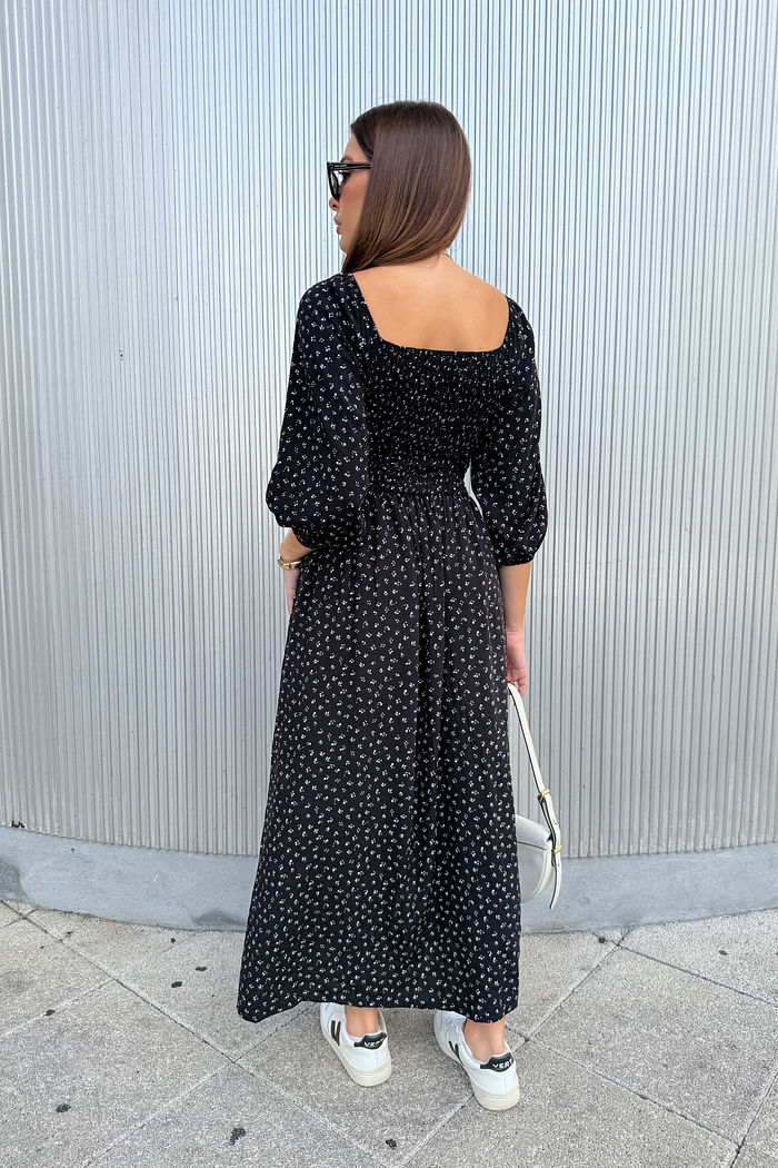 vestido midi preto em viscose com estampa micro floral delicada, busto com lastex, mangas ajustáveis e fenda lateral, caimento leve e fluido