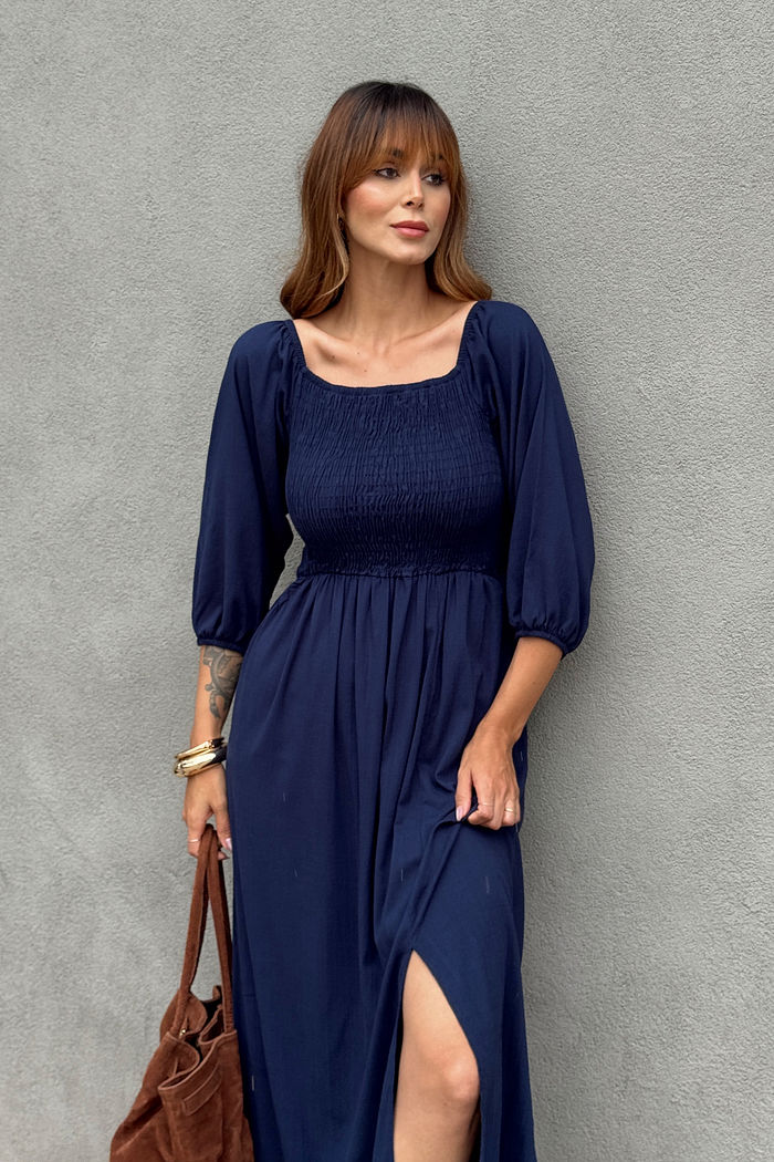 Vestido midi azul marinho em viscolinho com lastex no busto, mangas versáteis e fenda lateral, modelagem fluida em look casual feminino com tênis branco