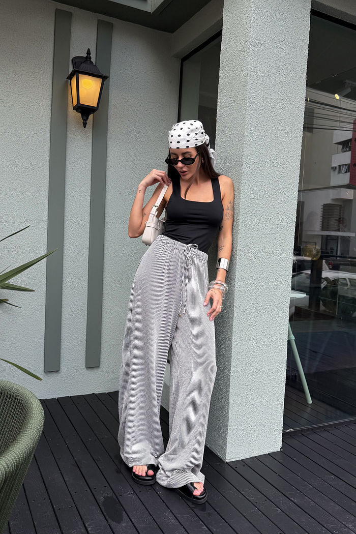 Calça feminina preta com modelagem reta e pernas amplas, caimento leve e visual elegante confortável