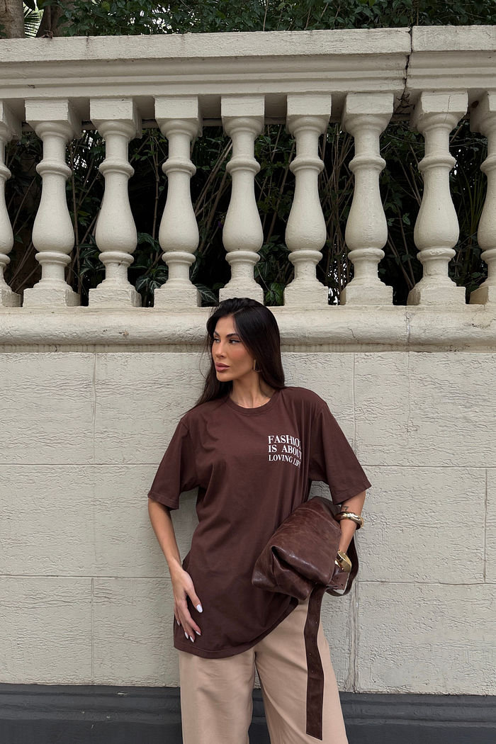 Camiseta feminina marrom em modelagem regular levemente solta, estampa frontal localizada em tipografia, manga curta, caimento confortável e proposta casual atual
