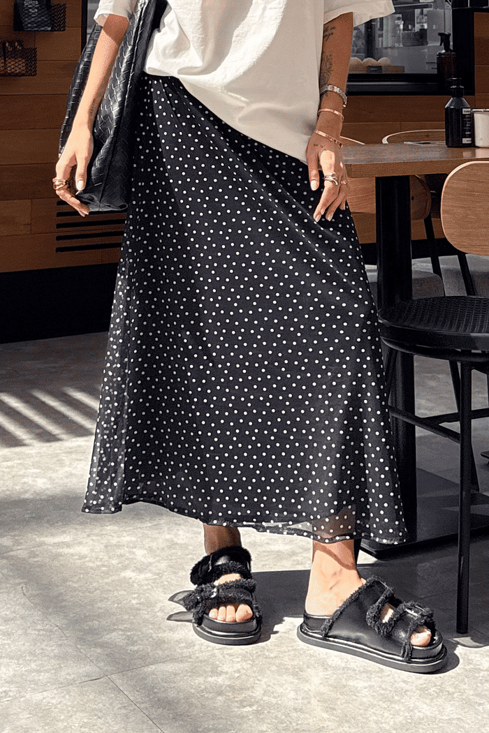 Saia midi de tule com estampa poá, leve e fluida, com forro embutido e cós elástico confortável.