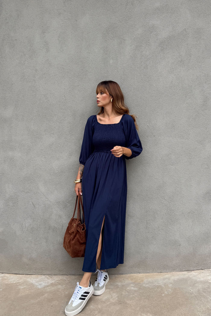 Vestido midi azul marinho em viscolinho com lastex no busto, mangas versáteis e fenda lateral, modelagem fluida em look casual feminino com tênis branco