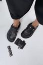 Clog feminino preto com franjas usado nos pés em composição de produto