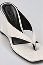 tamanco-feminino-dedo-salto-anabela-off-white-misaki Close do tamanco dedo off white, destacando a tira flip flop e a palmilha preta com a marca hitzz gravada.