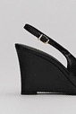 Detalhe Salto Naomi Preto Close do salto anabela preto e da tira traseira com fivela ajustável do slingback feminino Naomi preto.