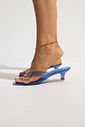 gummy-tamanco-salto-baixo-transparente-azul Tamanco Feminino Flip Flop Gummy azul em PVC translúcido nos pés da modelo, vista lateral