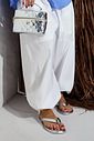 isla-flatform-feminina-croco-prata Chinelo Flat Feminino Isla Prata Croco nos pés em look feminino com bolsa metalizada