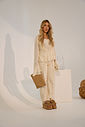 tamanco-feminino-plataforma-cortica-bege-kala Modelo usando look monocromático off-white com o Tamanco Feminino Plataforma Cortiça bege, corpo inteiro