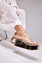 tamanco-flatform-feminino-tira-vinil-dourado-adele Detalhe do solado flatform do Adele - Tamanco Flatform Feminina Tira Vinil Dourado no pé da modelo sentada