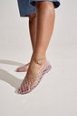 sapatilha-feminina-transparente-gummy Closeup dos pés em movimento calçados com a Sapatilha Feminina Transparente - Gummy, com saia jeans e tornozeleira dourada com pingente.