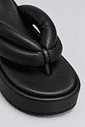 chinelo-flatform-tiras-puffer-preto-sakura Close-up macro do nó da tira acolchoada e do bico do Chinelo Flatform Tiras Puffer Preto - Sakura, destacando a textura e o acabamento