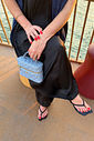 agnes-bolsa-feminina-lateral-matelasse-jeans Mulher usando Bolsa Feminina Matelassê Agnes jeans com alça longa na transversal.