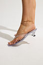 gummy-tamanco-feminino-transparente-salto-baixo Tamanco Feminino Flip Flop Gummy transparente em PVC nos pés da modelo, destacando as tiras e o salto baixo