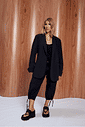 nyx-tamanco-femnino-tira-de-dedo-preto Tamanco Feminino Nyx preto nos pés, combinado com look all black de blazer e calça cargo.