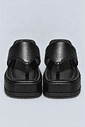 chinelo-flatform-couro-feminino-preto-buzios Par de chinelos flatform couro preto vistos de frente, mostrando a tira entre os dedos e o solado.