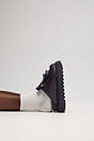 Clog feminino preto com solado plataforma em vista lateral