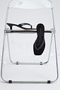 gummy-tamanco-feminino-salto-baixo-translucido-preto Tamanco Feminino Flip Flop Gummy preto em PVC sobre cadeira metálica, vista superior destacando as tiras e o bico quadrado