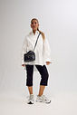 Look completo com Tênis Victoria Off White Modelo de corpo inteiro usando Tênis Feminino Victoria Off White com camisa branca oversized, calça preta cropped e bolsa preta transversal.