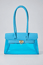 gummy-bolsa-feminina-transparente-verniz-azul-claro Bolsa Feminina Transparente Verniz Gummy azul claro com alças longas e fecho metálico dourado frontal.