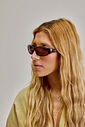olympia-oculos-feminino-tartaruga Mulher usando Óculos de Sol Feminino Olympia tartaruga visto de perfil.