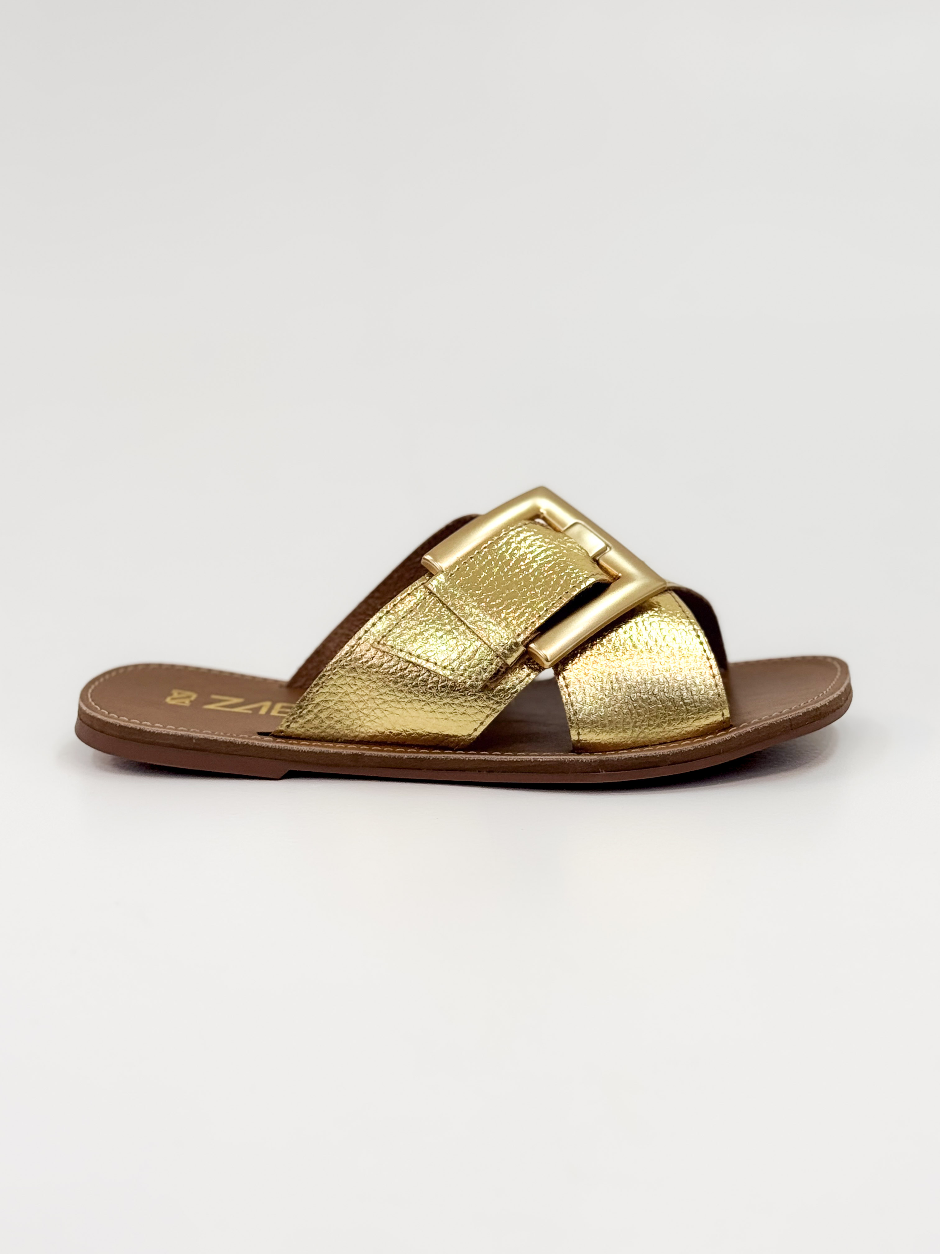 Joanice — Chinelo Rasteira Ouro com Fivela Dourada Joanice — Chinelo Rasteira Ouro com Fivela Dourada