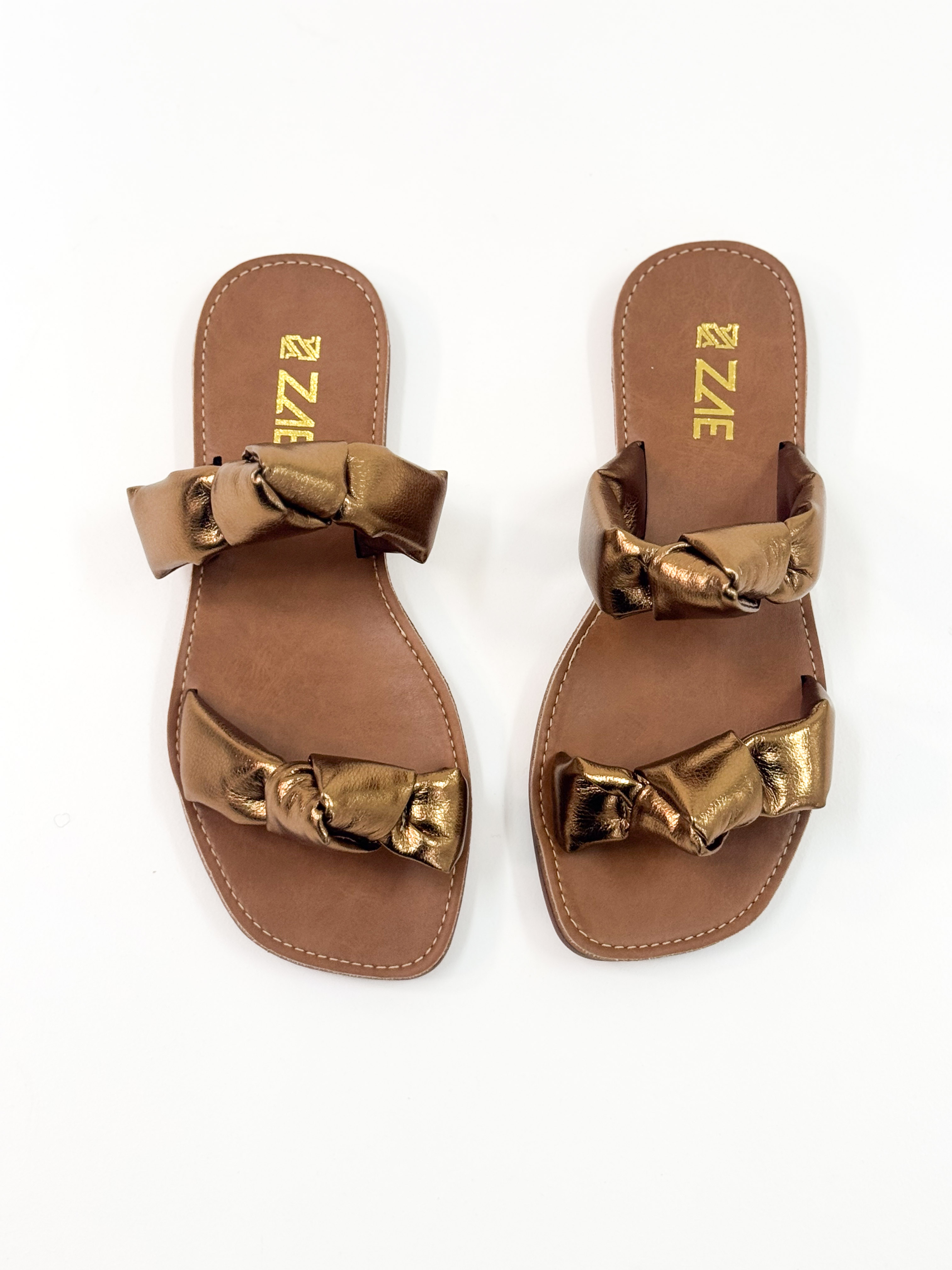 Luana — Chinelo Rasteira Bronze com Tiras Torcidas Luana — Chinelo Rasteira Bronze com Tiras Torcidas
