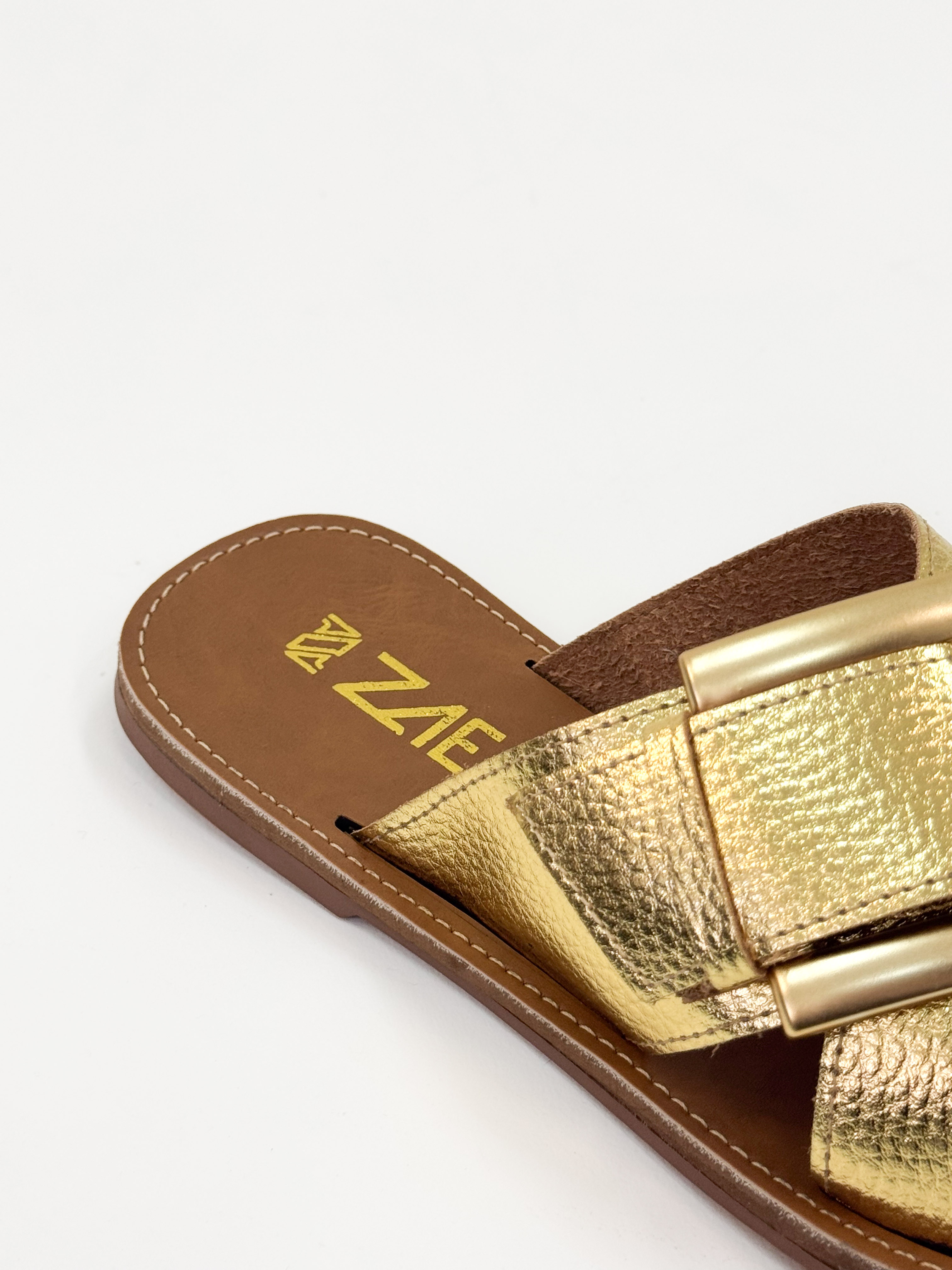 Joanice — Chinelo Rasteira Ouro com Fivela Dourada Joanice — Chinelo Rasteira Ouro com Fivela Dourada