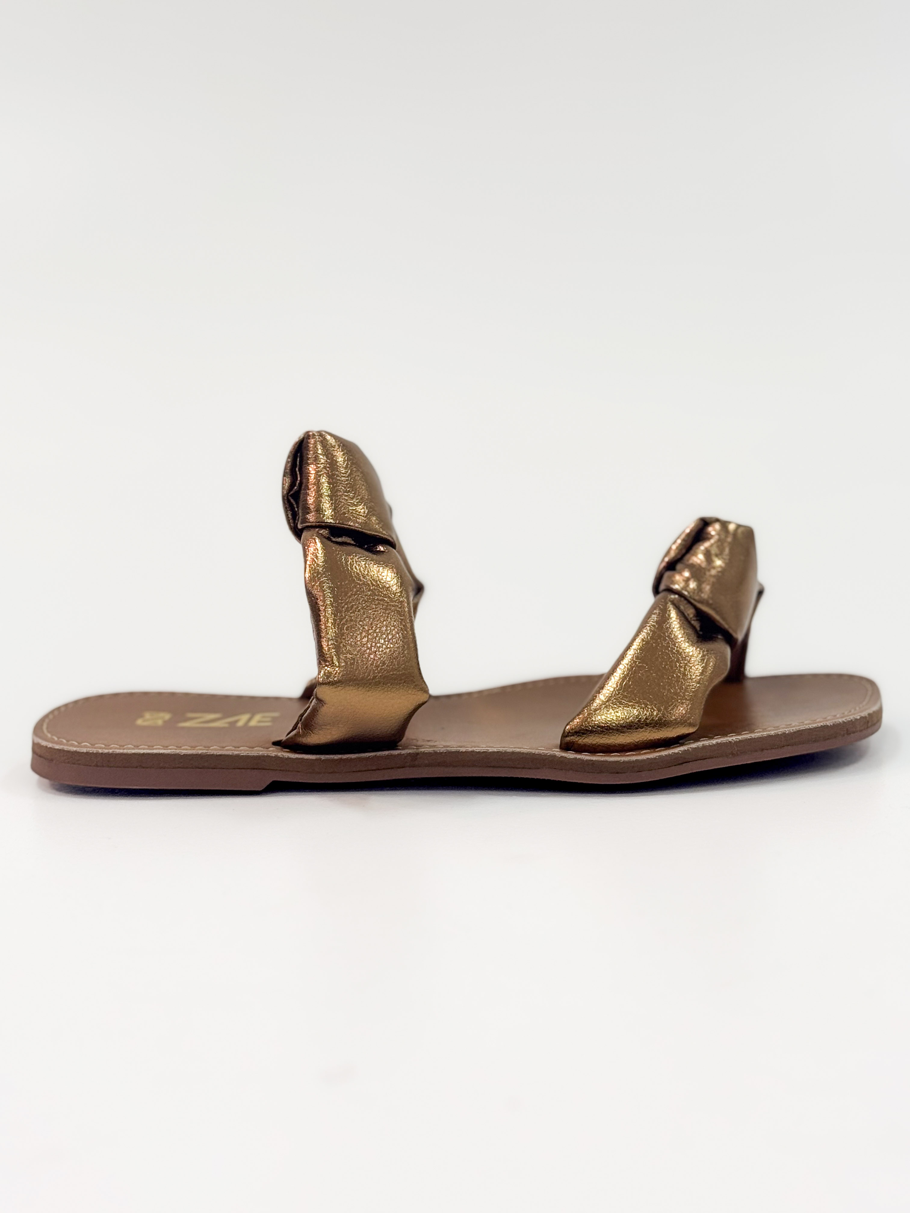 Luana — Chinelo Rasteira Bronze com Tiras Torcidas Luana — Chinelo Rasteira Bronze com Tiras Torcidas