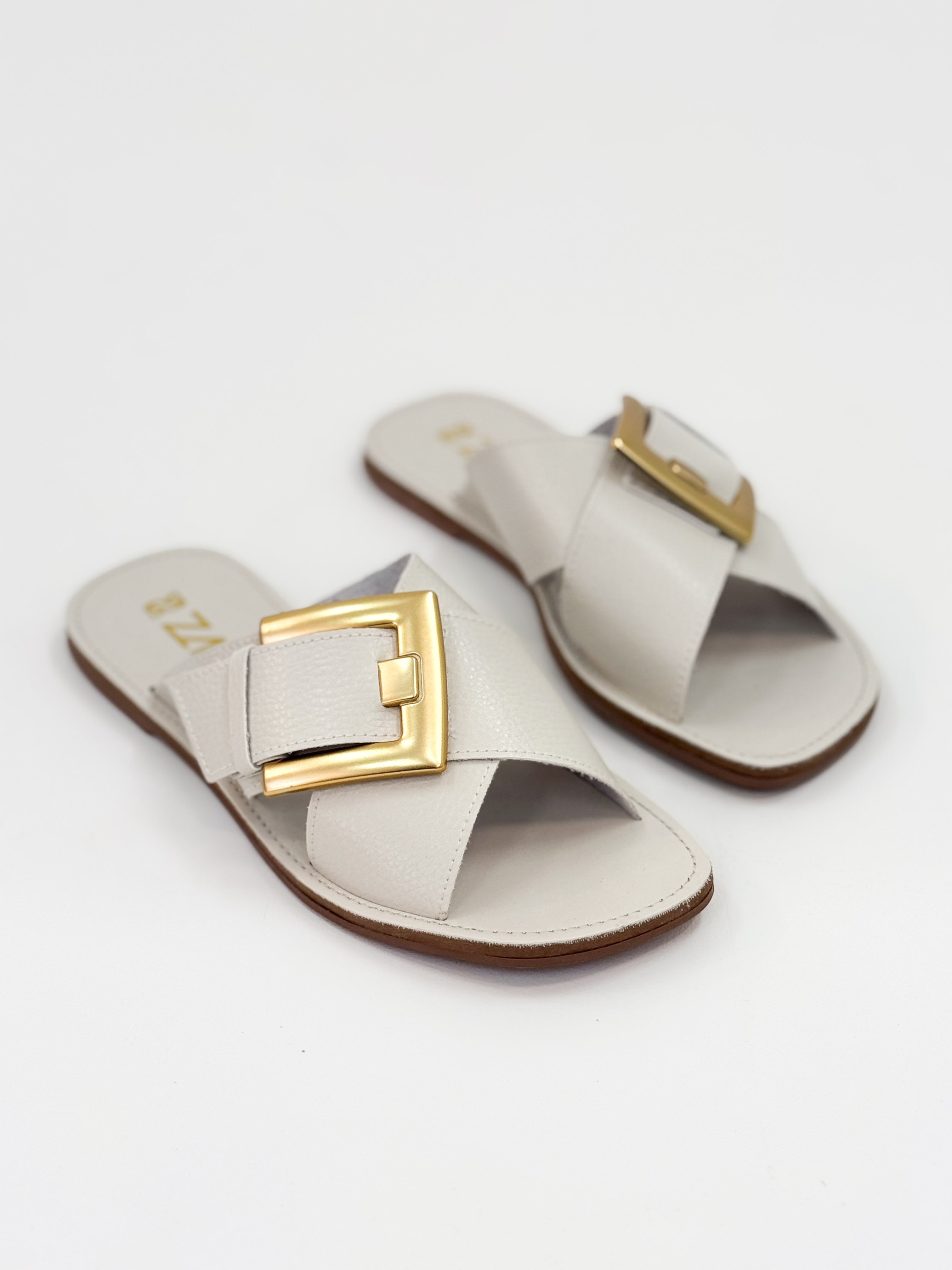 Joanice — Chinelo Rasteira Off White com Fivela Dourada Joanice — Chinelo Rasteira Off White com Fivela Dourada