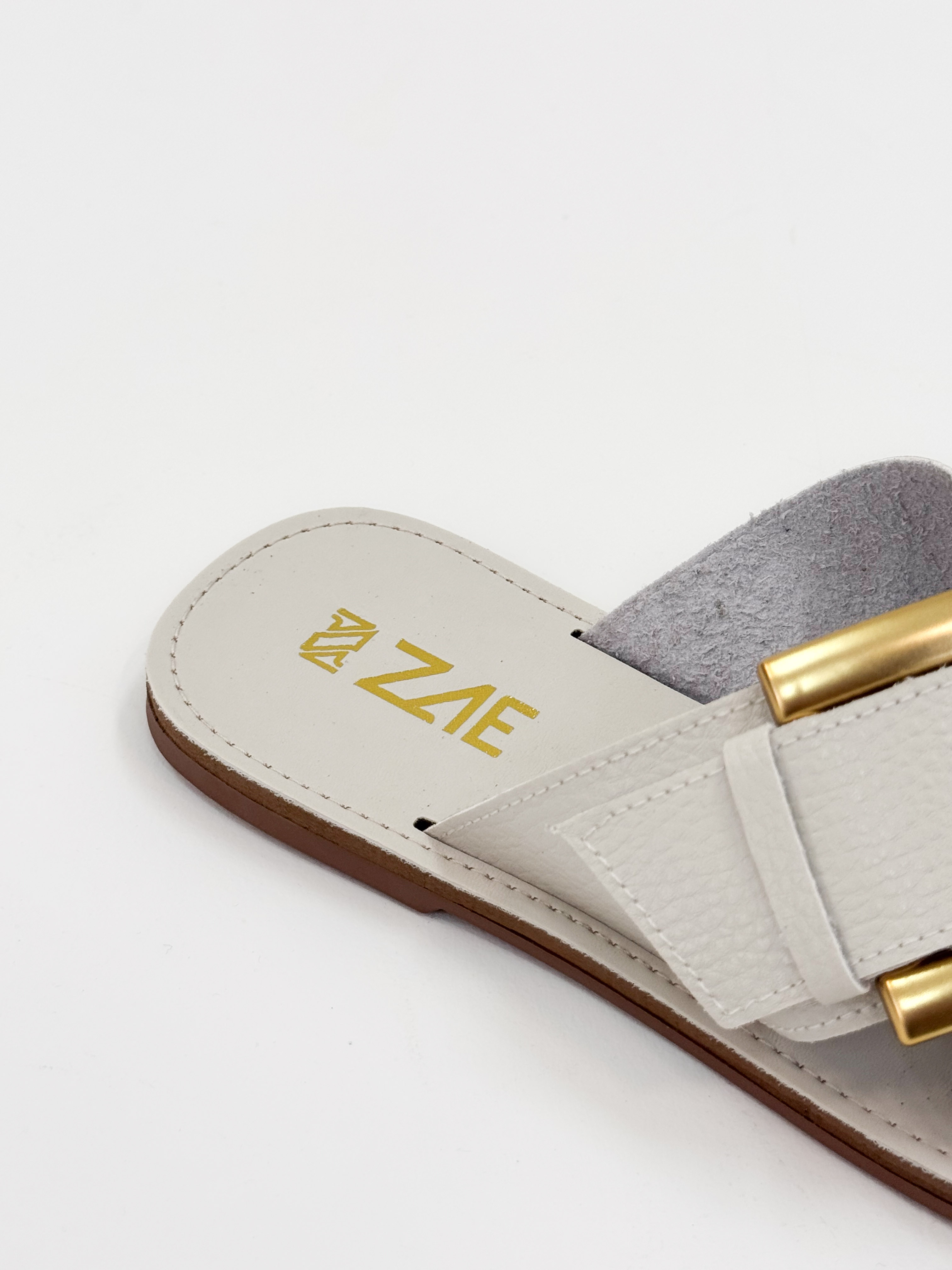 Joanice — Chinelo Rasteira Off White com Fivela Dourada Joanice — Chinelo Rasteira Off White com Fivela Dourada