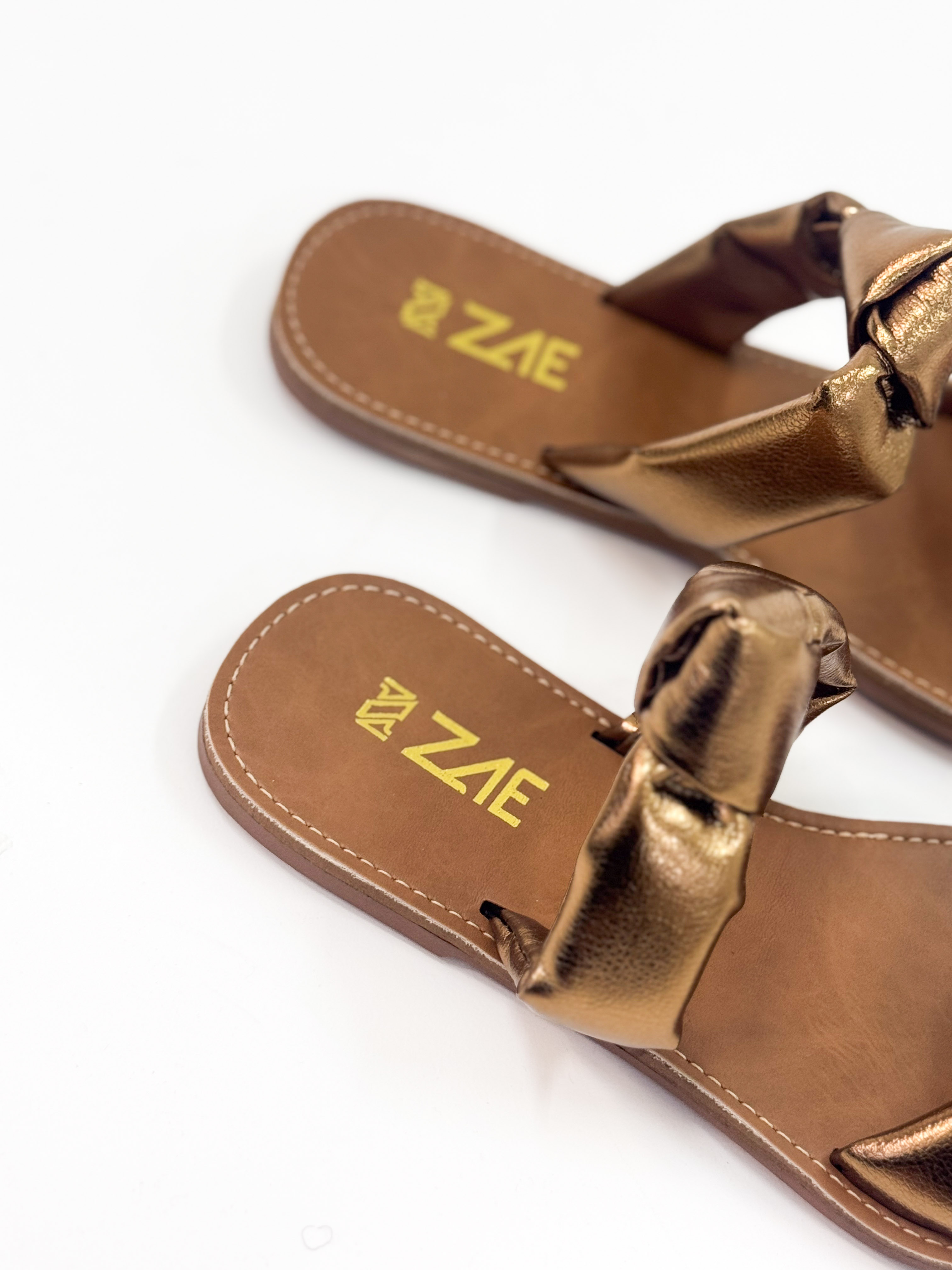Luana — Chinelo Rasteira Bronze com Tiras Torcidas Luana — Chinelo Rasteira Bronze com Tiras Torcidas
