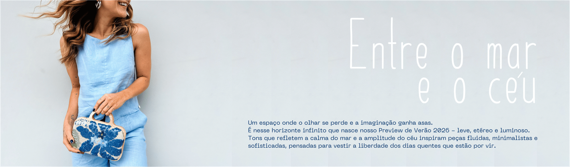 Modelo usando conjunto azul claro com bolsa bordada azul em frente a parede clara. Texto: "Entre o mar e o céu – Preview Verão 2026