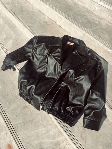 Jaqueta de couro oversized preta Jackie Mundo Lolita Jaqueta de couro da marca Mundo Lolita posicionada no chão