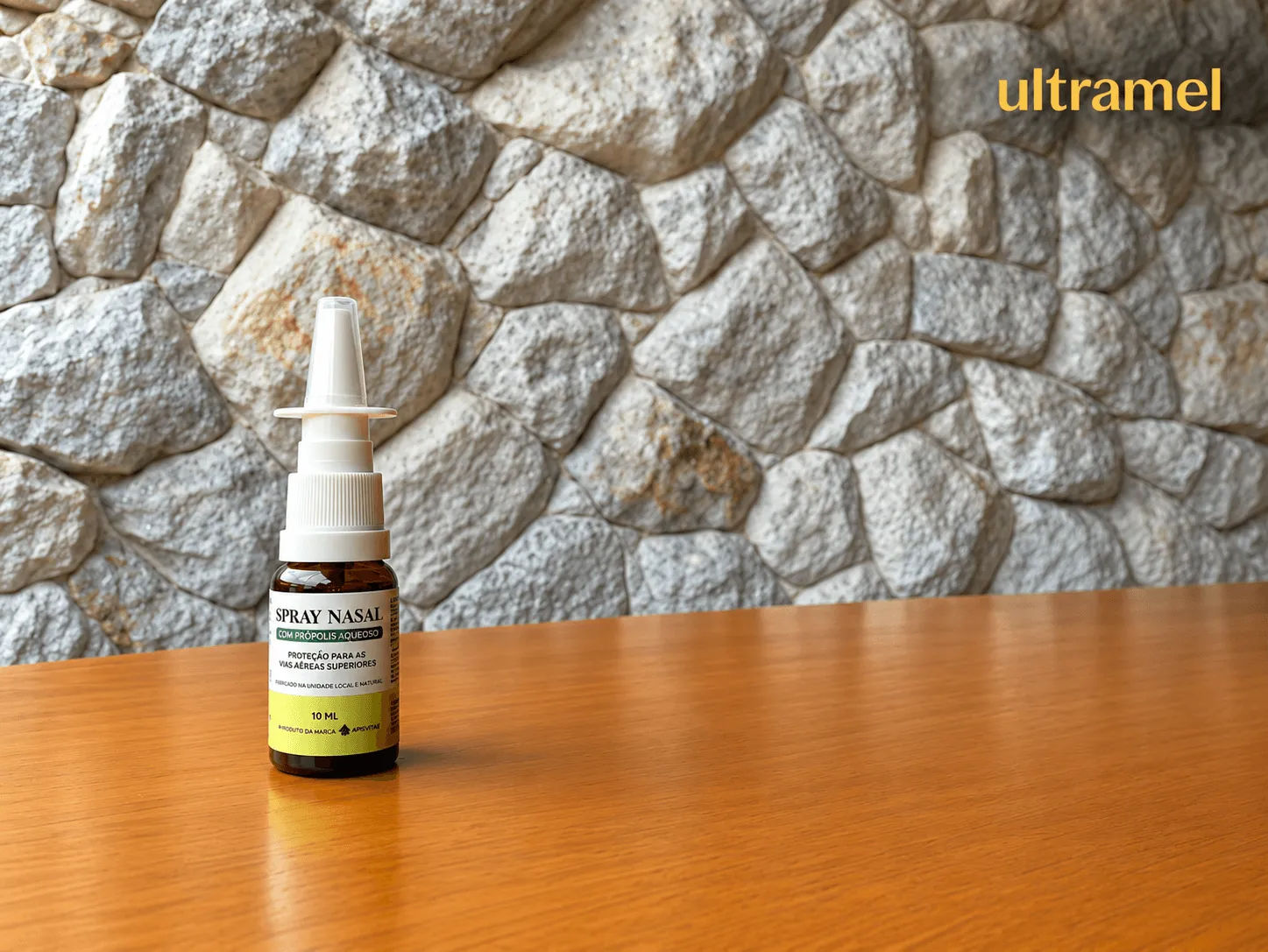 Frasco de spray nasal com própolis aquoso da marca Apivitae, de 10 ml, sobre uma mesa de madeira com parede de pedra ao fundo. O produto promete proteção para as vias aéreas superiores e é comercializado pela Ultramel.