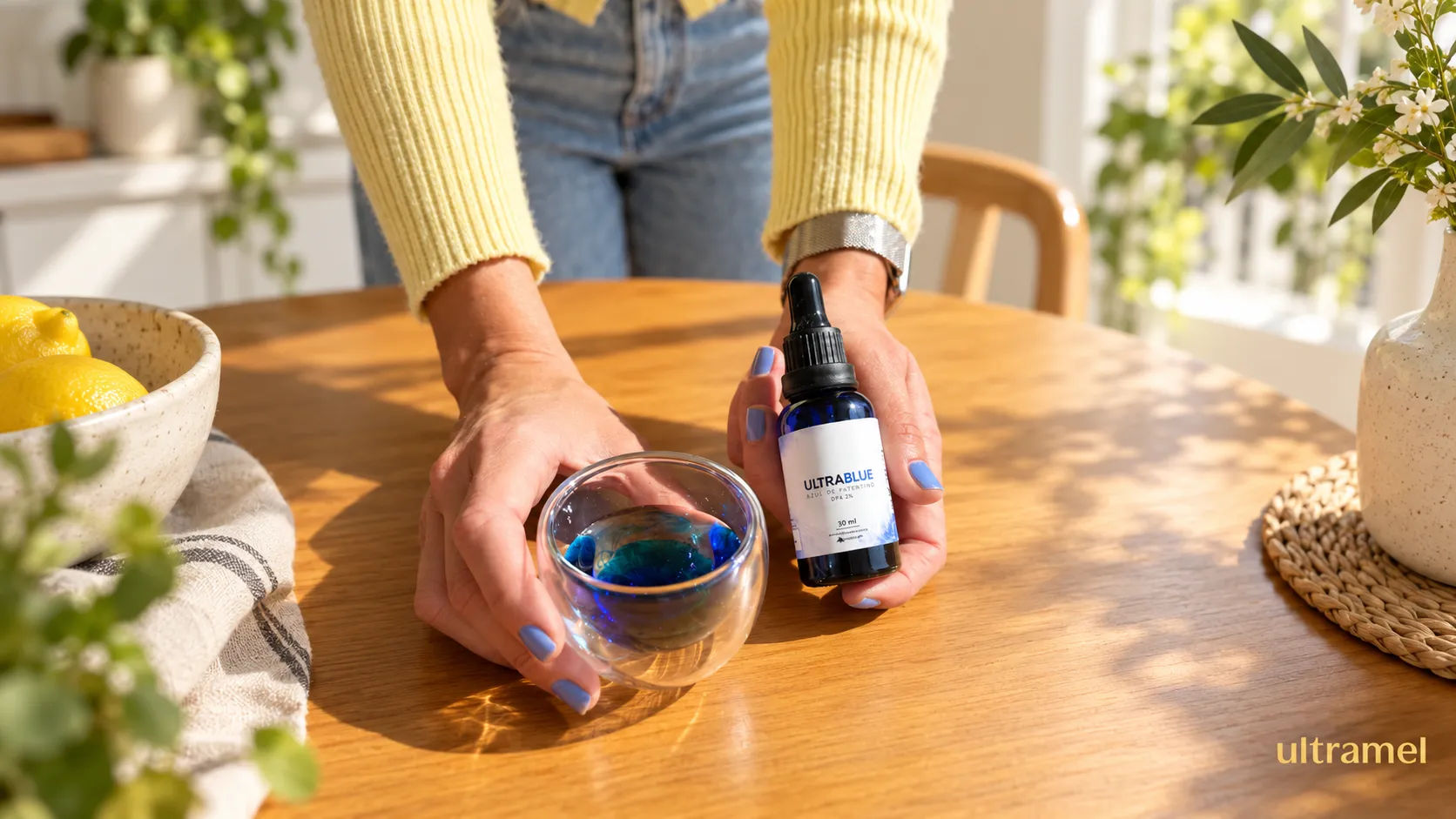 Frasco gotejador do UltraBlue Azul de Metileno PA 2% da Ultramel ao lado de um copo de vidro com líquido azul, sobre uma superfície de palha. O produto é apresentado com a proposta de saúde celular, energia e proteção do organismo.