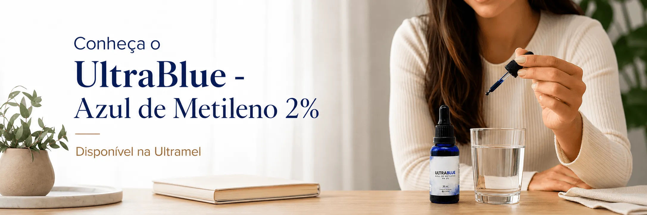 Mulher utilizando um conta-gotas para adicionar gotas do produto UltraBlue Azul de Metileno 2% em um copo com água, sobre uma mesa de madeira com caderno e planta ao fundo.