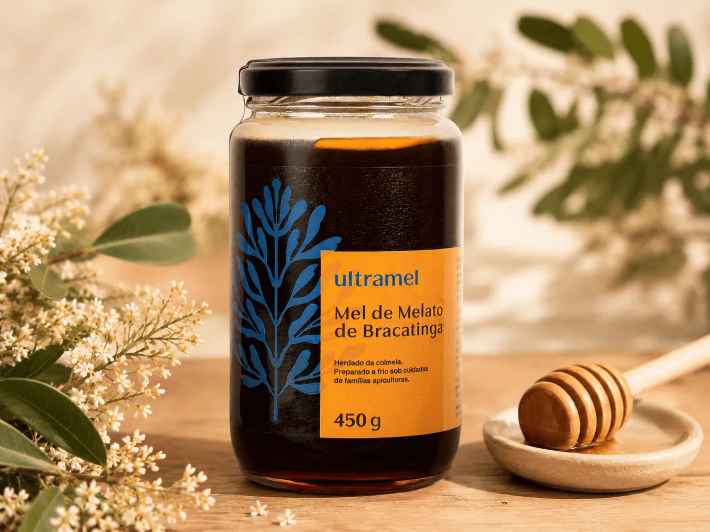 Pote de 450g de Mel de Melato de Bracatinga da marca Ultramel sobre uma mesa de madeira, acompanhado de um bastão de mel e flores brancas da bracatingueira ao fundo.