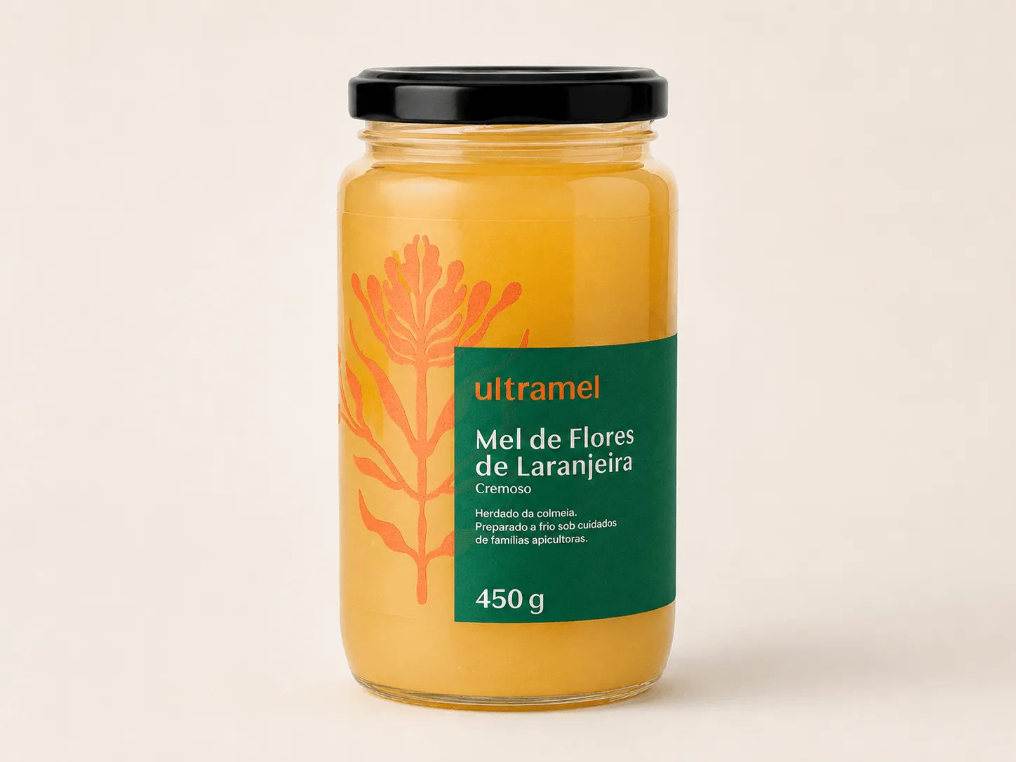 Pote de vidro de 450g de mel cremoso de flores de laranjeira da marca Ultramel, com tampa preta e rótulo verde-escuro, sobre fundo bege claro. O produto é preparado a frio e possui ilustração botânica em tons alaranjados no rótulo.