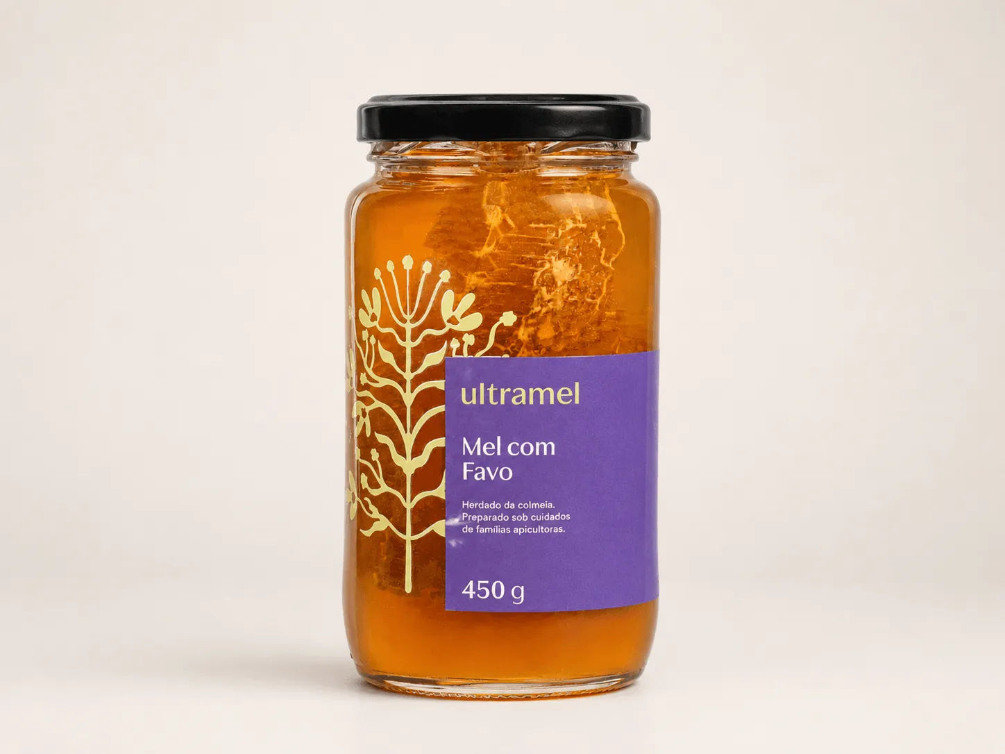 Pote de vidro de mel com favo da marca Ultramel, com tampa preta e rótulo roxo, contendo 450g do produto. Ao fundo do vidro transparente, é possível ver um pedaço de favo de mel mergulhado no mel dourado.