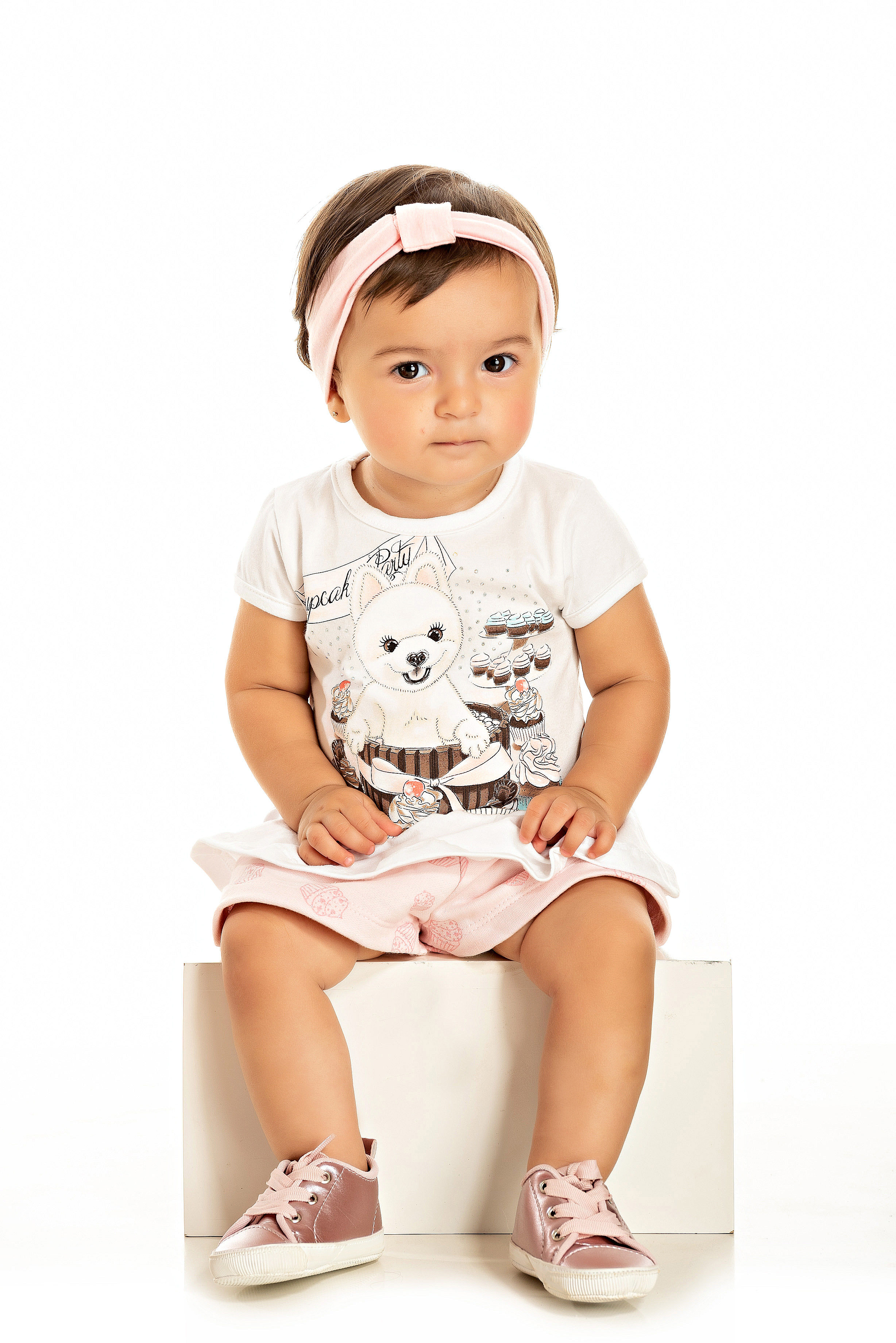 Bebê sentado com conjunto infantil